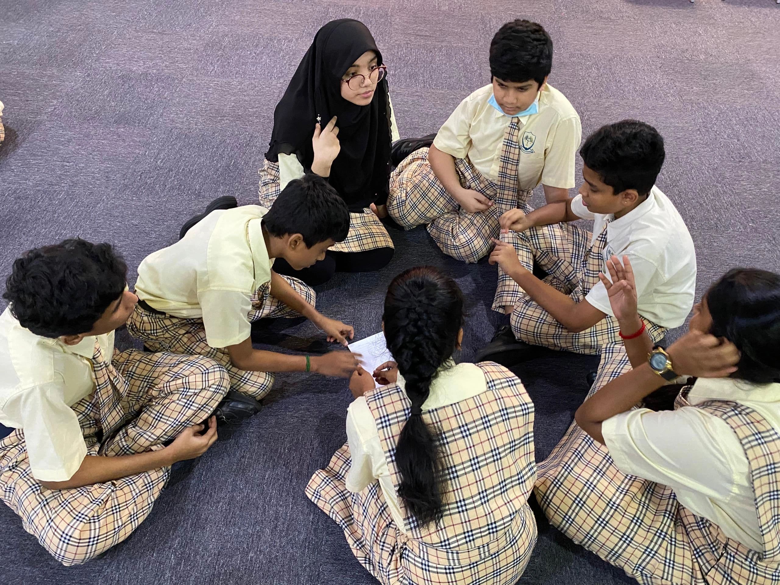 Students in uniform working together on the floor