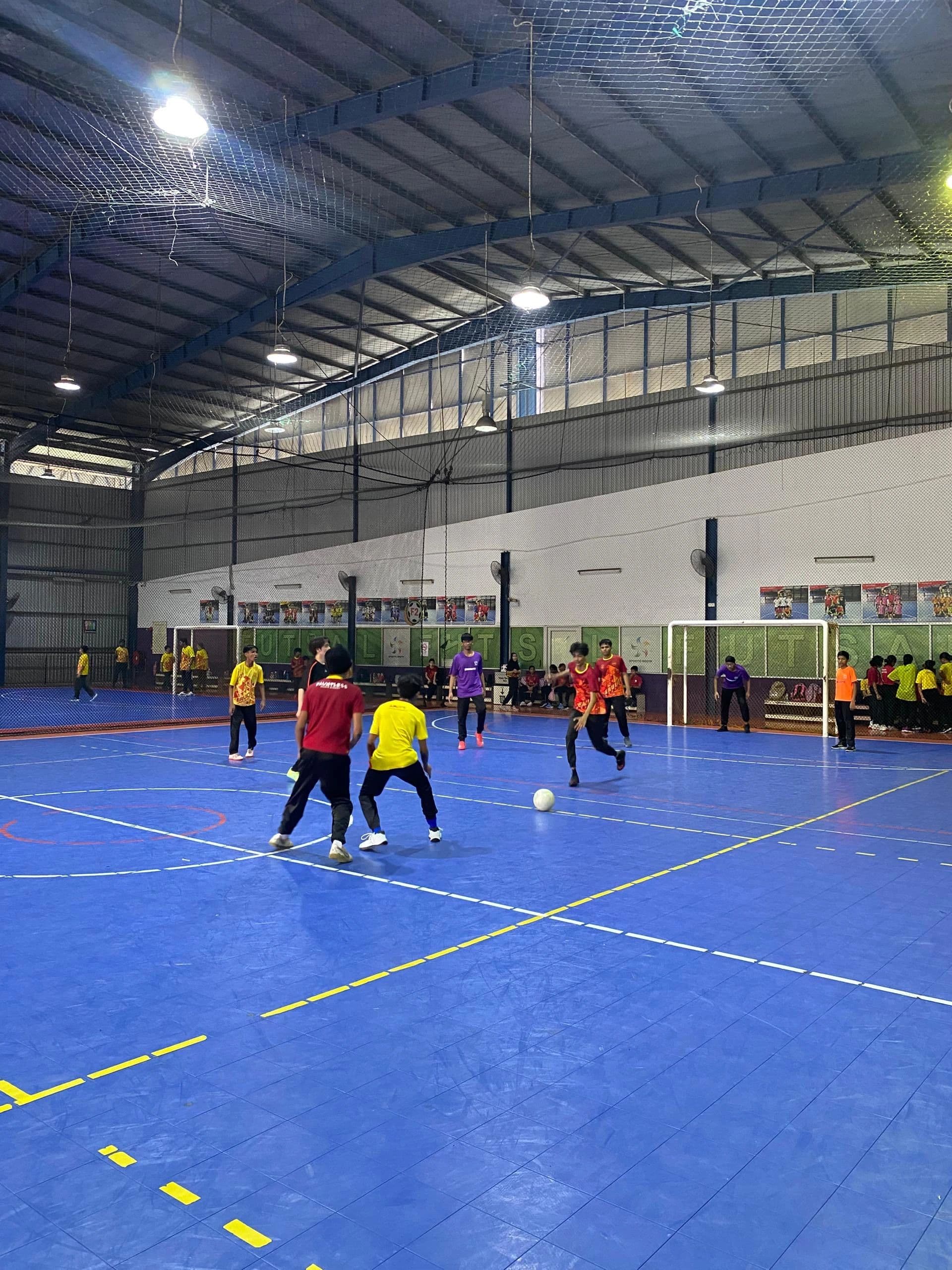 Students playing futsal indoors