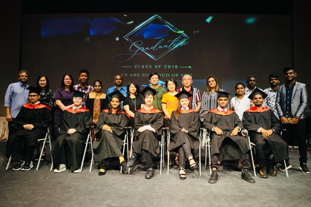 Graduates in gowns seated together
